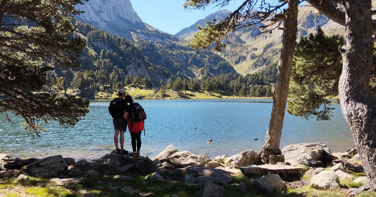 un couple amoureux à l’ombre contemple la paix d’un lac de montagne